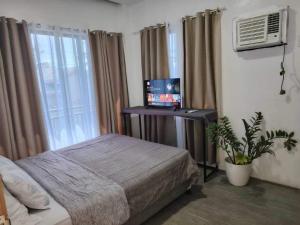 a bedroom with a bed and a television in it at Yannas transient house in Roxas City