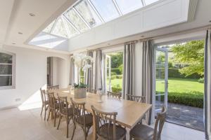 にある7 Bed in Combe Hay oc-bhr21のテーブルと椅子、そして大きな天窓のあるダイニングルーム