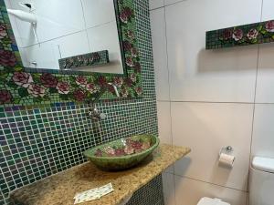 a bathroom with a sink and a mirror at Pousada Leão in Maceió