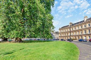 a tree in front of a building with a grass field at 2 Bed in Bath oc-bhr16 in Bath