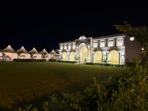 a large building at night with its lights on at Rambagh Resort by Stotrak, Gwalior in Gwalior