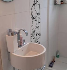 a white sink in a bathroom with a shower at APARTAMENTO KOBRASOL - Bem localizado in São José
