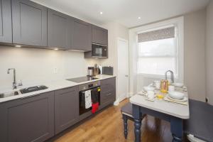 バースにある2 Bed in Bath oc-bhr42のキッチン(グレーのキャビネット、テーブル、シンク付)