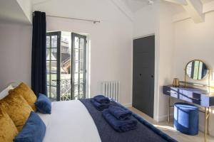 1 dormitorio con cama con almohadas azules y espejo en 2 Bed in Bath oc-bhr8, en Bath