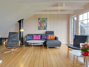 un salon avec un canapé bleu et des chaises dans l'établissement Fjord View Retreat - By Traum Ferienwohnungen, à Falen 15 autres photos