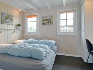 une chambre avec quatre oreillers sur un lit et deux fenêtres dans l'établissement Fjord View Retreat - By Traum Ferienwohnungen, à Falen