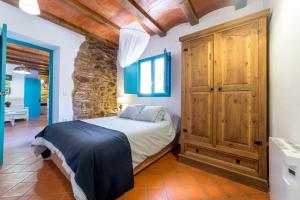 ein Schlafzimmer mit einem Bett und einem Holzschrank in der Unterkunft Villa Rotonda in Alquerías del Niño Perdido + 26 Fotos