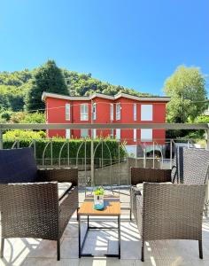 un patio con sedie e tavolo e un edificio rosso di La casa di Sebastian a Como Altre 25 foto