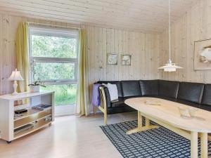 a living room with a black couch and a table at 4 star holiday home in Ålbæk in Ålbæk