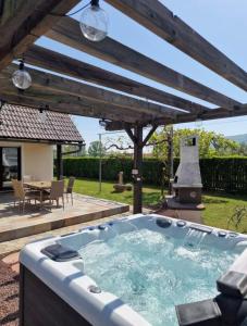 Un jacuzzi en un patio con parrilla. en Villa Vili - Jacuzzi, BBQ & EV Outlet, en Limbuš