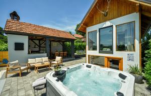 a hot tub on a patio next to a house at Cozy Home In Vrtlinovec With Sauna in Vrtlinovec