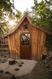 a wooden shed with a door in a yard at Bulles d'Olive Olea - Piscine & Jacuzzi avec vue in Nyons +8 photos