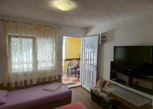 a living room with a flat screen tv and a living room at Apartmani Jelena in Neum