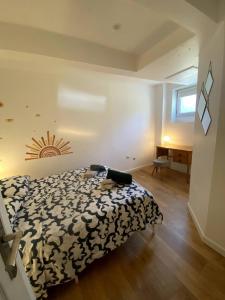 a bedroom with a bed with a black and white comforter at Maison climatisée Lyon-Bron Eurexpo - Stadium Groupama - Interdit aux événements in Bron