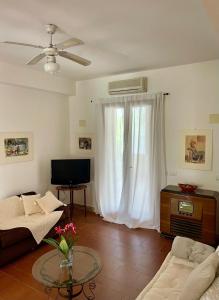 a living room with a couch and a tv at Villa VerdeMare Pool-Sea 300m-Nature Reserve in Plaia Grande