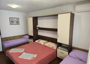 a bedroom with two beds with purple sheets at Apartmani Jelena in Neum