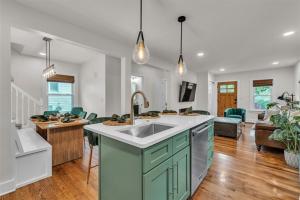 a kitchen with a sink and a living room at The Treehouse at Treetown by Granger Gardens in Ann Arbor