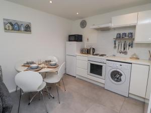 a kitchen with a table and chairs and a stove and oven at 51 Longstone Park in Chathill