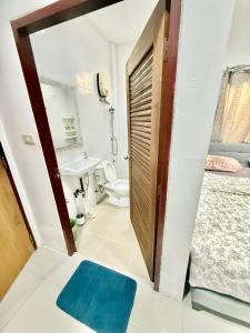 Un baño con inodoro, lavabo y espejo. en Warisa Grand 3 bedroom Villa, en Pattaya South