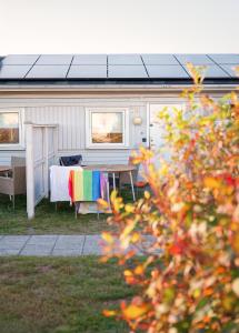 a caravan with a table and a rainbow blanket at Apelvikstrand Lägenheter in Varberg