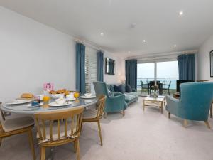 een woonkamer met een tafel, stoelen en een bank bij Far Cliffs in St Ives