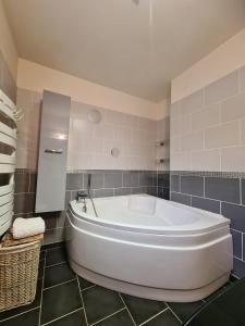 a large white tub in a bathroom with tiles at Maison Gallardon in Gallardon +16 photos
