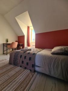 a bedroom with a large bed with a red wall at Maison Gallardon in Gallardon