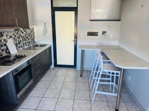 a kitchen with a counter and some chairs in it at Flat in Khomas Region