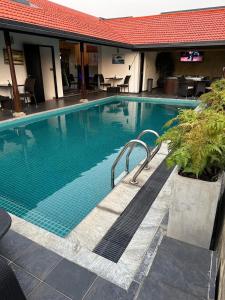a swimming pool in a hotel with a table and chairs at D Villas in Sri Jayewardenepura Kotte