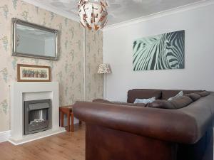 ein Wohnzimmer mit Couch und Kamin in der Unterkunft Gwenynen Fel Cottage in Burry Port