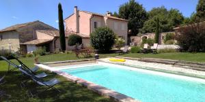 a swimming pool in the yard of a house with a house at Mas des Treilles - Chambre d'hôtes "Côté Villages" in Mane