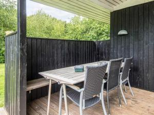 a wooden table and chairs on a wooden deck at 5 person holiday home in Odder in Odder