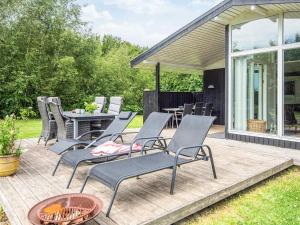 a patio with chairs and a table and a grill at 5 person holiday home in Odder in Odder