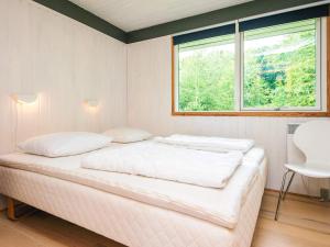 a white bedroom with a bed and a window at 5 person holiday home in Odder in Odder