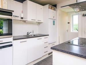 a kitchen with white cabinets and black counter tops at 5 person holiday home in Odder-By Traum in Odder