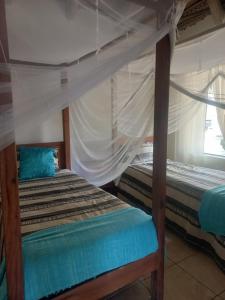 a bedroom with two bunk beds and a window at Silver Fish Resort in Maxixe +15 photos