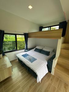 a bedroom with a bed in a room with windows at Poolla Poolla Villa Khaoyai in Pak Chong