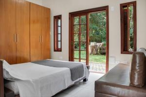 Un dormitorio con una cama y una puerta corrediza de vidrio. en Chácara Casa Ampla no Lago Piscin Churrasqueira, en São Bernardo do Campo