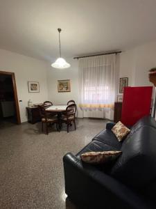 a living room with a black leather couch and a table at Bed and Breakfast Santu Tomas in Bitti