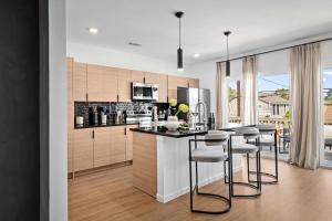 eine Küche mit einer Insel mit Barhockern in der Unterkunft Luxe Spa Lounge, Gated 4 Parking, 2 linked Homes, Sleeps 20 in Houston