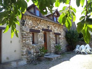 a stone house with two chairs in front of it at 3 Gites au grande Vigne in Saint-Étienne-sous-Bailleul