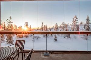 a room with a view of the snow covered trees at Peak Chalet B6 Ski-in Ski-out by Aavalevi in Levi