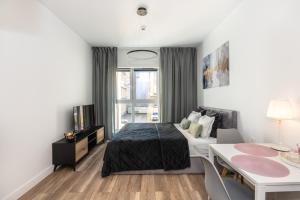 a bedroom with a bed and a table and a desk at Super-Apartamenty Plac Wolności 6 in Poznań
