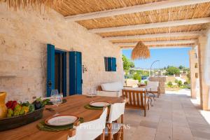 an outdoor dining room with a table and chairs and a dining room at I Trulli del Tarassaco with private pool by Pregio Villas in Martina Franca
