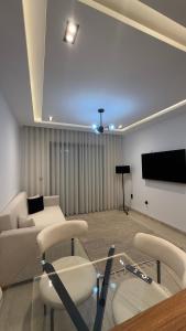 a living room with a couch and a flat screen tv at Luxury apartment in Sidi Daoud