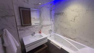 a white bathroom with a sink and a tub at Luxury apartment in Sidi Daoud +9 photos