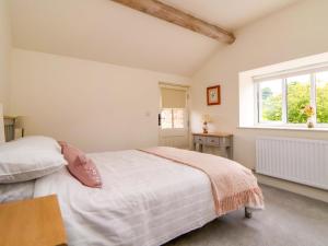 un dormitorio con una cama y una ventana en Isfryn, en Mold
