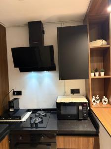 a kitchen with a stove and a microwave at Luxury apartment in Sidi Daoud