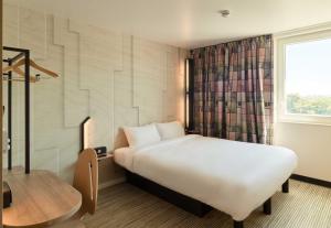 a hotel room with a white bed and a window at B&B HOTEL Meaux Nanteuil-lès-Meaux in Nanteuil-lès-Meaux