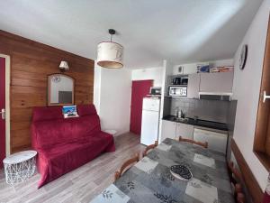 un salon avec un canapé rouge et une table dans l'établissement Logement 4/6 personnes à la montagne avec piscine, à Saint-Sorlin-dʼArves